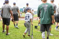 Zander Clark of West Fairlee, VT walks onto Centennial Field in Burlington, VT with players from the Vermont Lake Monsters, minor league baseball team, on Friday, Aug. 14, 2015. (Oliver Parini photograph)